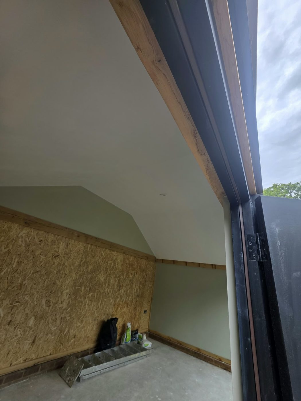 Exposed oak beam framing an opening out to the garden