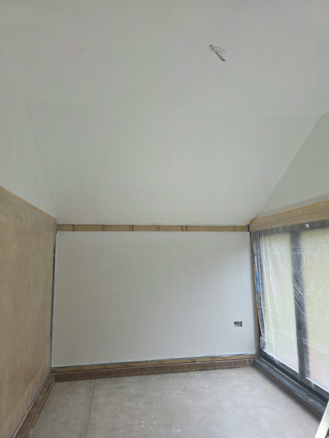 Freshly plastered room with the window sheeted for protection